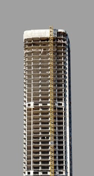 Under construction tall skyscraper in downtown city. Unfinished facade of high-rise residential photo