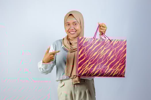 Happy Muslim Woman Holding Shopping Bag with a Smile photo