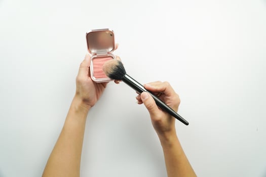 A person holding a brush and a blush in their hand photo