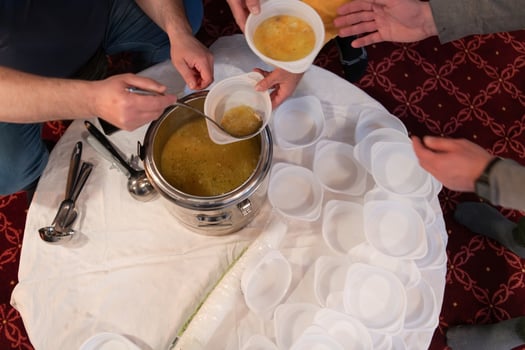 Top view of people serving food at a Mosque a communal meal during Ramadan before breaking the fast on Iftar dinner. Warm festive atmosphere celebrating Ramadan Karim and Eid, the Islamic holy month photo