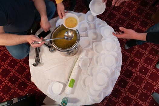 Top view of people serving food at a Mosque a communal meal during Ramadan before breaking the fast on Iftar dinner. Warm festive atmosphere celebrating Ramadan Karim and Eid, the Islamic holy month photo