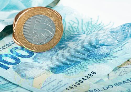 Brazilian money. Close-up of Brazilian Real currency, featuring a 1 Real coin resting on a 100 Real banknote photo