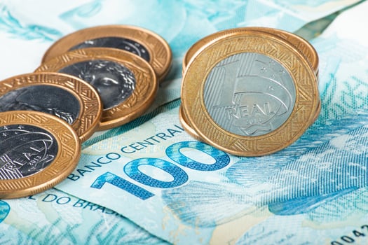 Brazilian money. Close-up of Brazilian currency, featuring a 100 Real banknote and several 1 Real coins photo