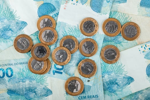 Brazilian money. Close-up of Brazilian currency, featuring 1 Real coins scattered on top of 100 Real banknotes. photo