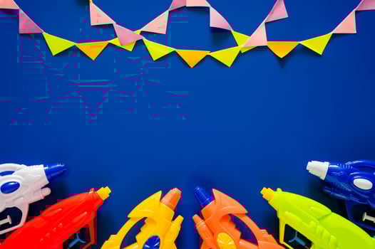 Water guns put on blue background with party flags for Minimal Thailand Songkran festival celebration concept. photo