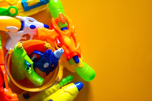 Water guns in yellow bucket and on yellow background for Thailand Songkran festival concept. photo