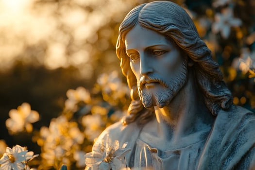 Statue of Jesus Christ with flowers during golden hour photo