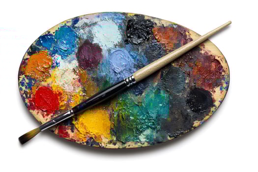 Paintbrush resting on an artist's palette covered in colorful oil paints photo
