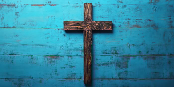 Wooden cross on a blue wooden background symbolizes faith and spirituality in a serene setting photo
