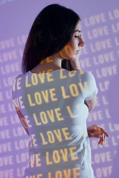 A woman standing in front of a wall with the words love written on it photo