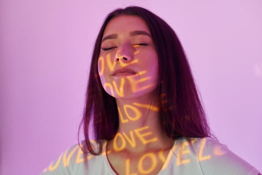 A woman with her eyes closed and the words love written on her forehead photo