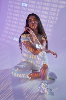 A woman sitting on the floor with a neon sign photo