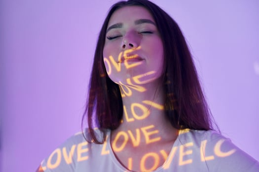 A woman with her eyes closed and the words love and love written on her face photo