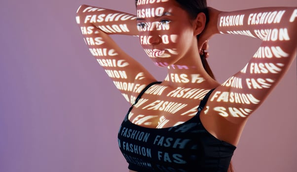 A woman with her hands on her head and a light shining on her face photo