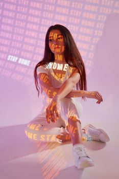 A woman sitting on the floor with neon text photo