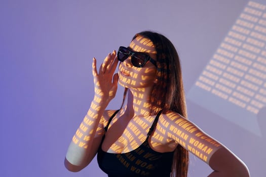 A woman wearing sunglasses and holding up a sign photo