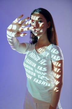 A woman holding up her hands with words projected on them photo