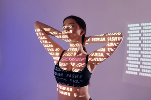 A woman in a bra top with words projected on her body photo