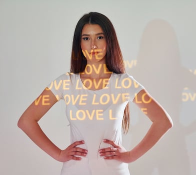 A woman standing in front of a wall with the words love and love written on it photo