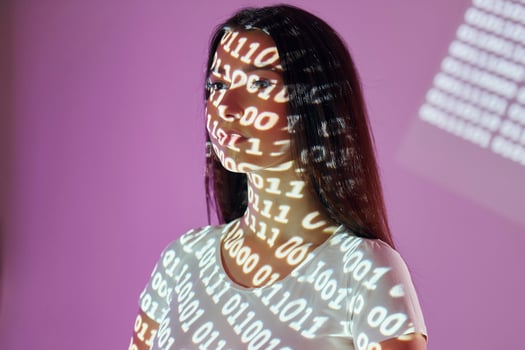 A woman with a white shirt and a computer screen behind her photo