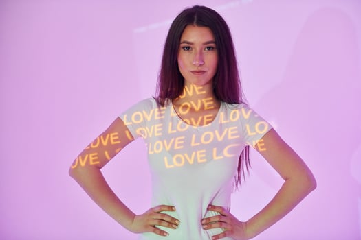A woman standing in front of a purple background with the words love love love photo