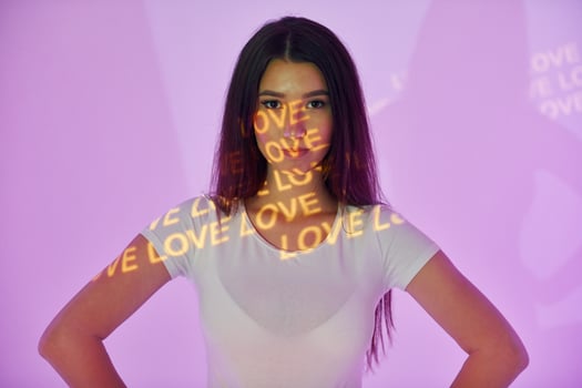 A woman standing in front of a purple wall with the words love is love written on it photo