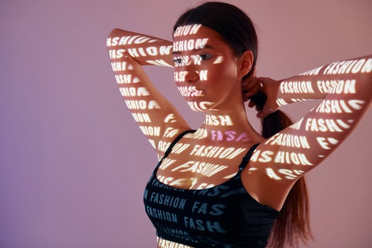 A woman in a sports bra top with words projected on her body photo