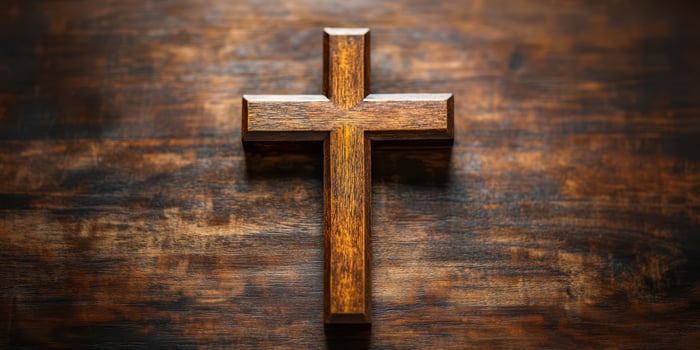 Wooden cross rests on a rustic table highlighting its simple elegance and symbol of faith and devotion photo