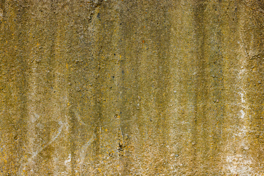 rough concrete wall with yellow stains photo