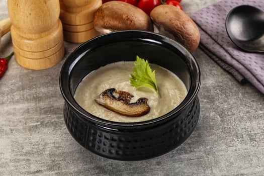 A bowl of soup with mushrooms and herbs photo