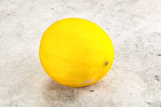 A yellow melon on a table photo