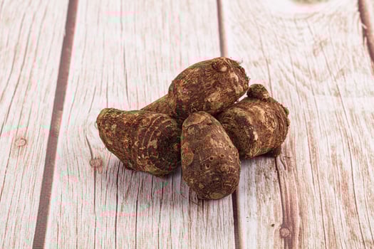 A pile of raw potatoes on a wooden table photo