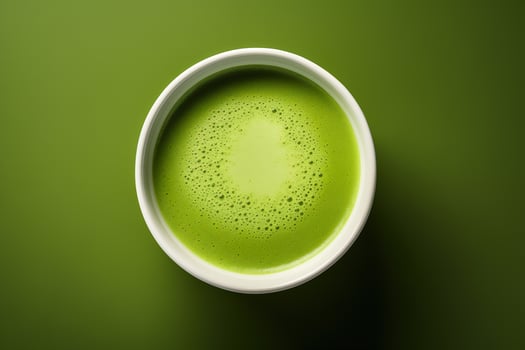 A bowl of green tea on a green background photo