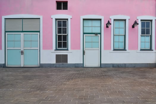 Bright pink wall with doors and windows invites exploration in a charming location photo