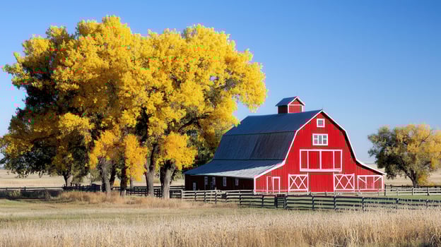 Classic Red Barn in Autumn Landscape with Golden Trees and Fence A picturesque rural scene perfect for fall themes photo