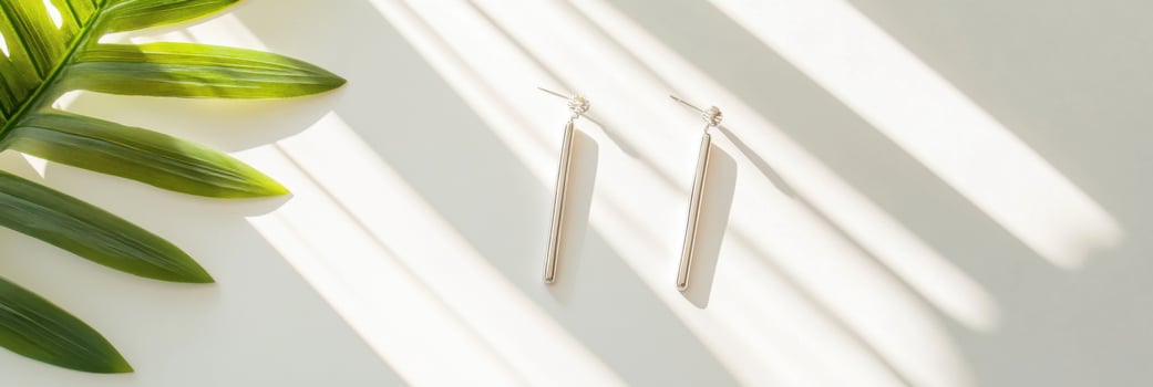 A pair of silver earrings on a white surface photo