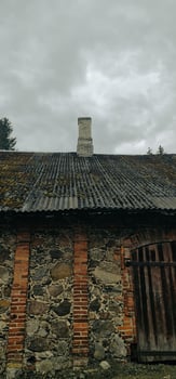 Abandoned vintage stone house with grey sky photo