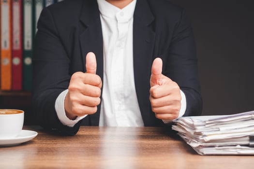 Businessman showing thumbs up to the success and best service while sitting at the table photo