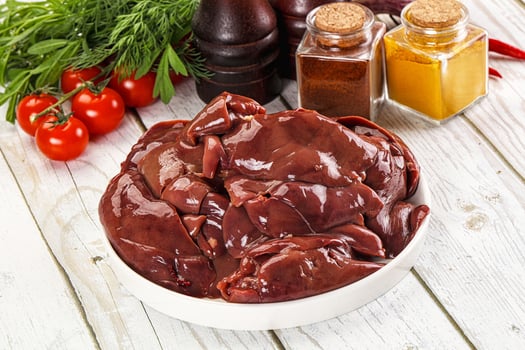 A bowl of raw meat on a table with other ingredients photo