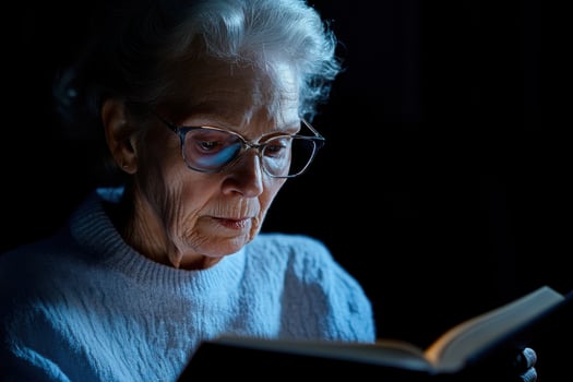 Senior woman reading book with trifocal glasses reflecting changes in vision and the need for eye care photo