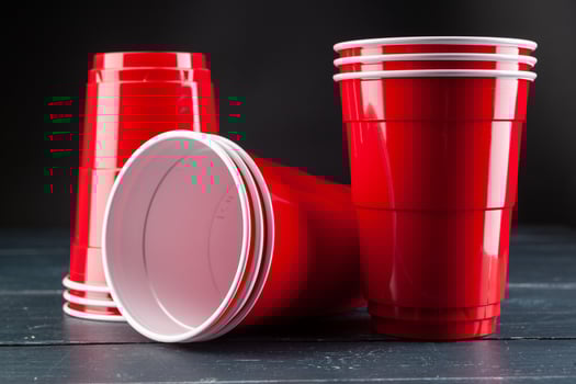 Wooden table with red cups and ball for beer pong photo