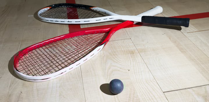 Squash rackets and ball on court floor, top view photo