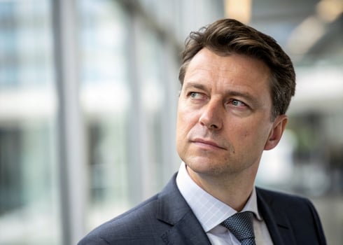 a man in a suit and tie looking off the side photo