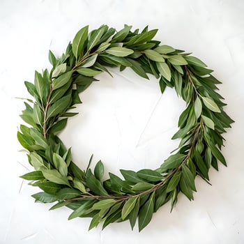 A beautiful green laurel wreath, carefully crafted with lush leaves, set against a clean white background, perfect for decoration or celebration photo