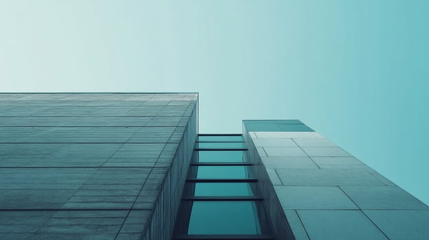 Abstract architectural shot showcasing converging building structures reaching towards a uniform, light teal sky. Modern aesthetics. photo