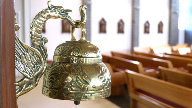 a golden bell sits in the middle of a church photo