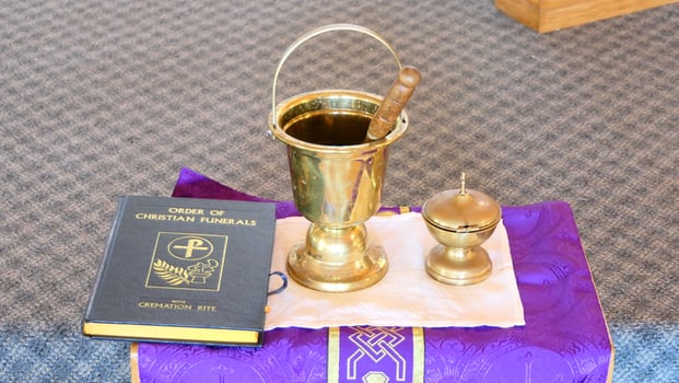 a golden cup and a bible on a purple cloth photo