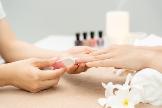 Woman receive care service by professional Beautician Manicure at spa centre. Nail beauty salon use nail file for Glazing treatment. manicurist make nail customer to beautiful body care spa treatment. photo