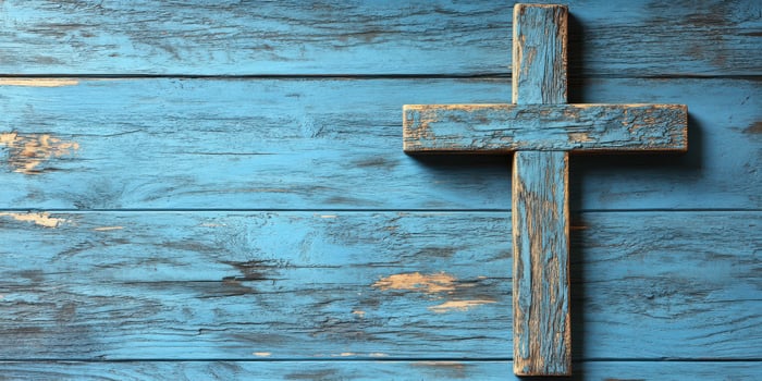 Wooden cross on blue weathered wooden background with textured details photo
