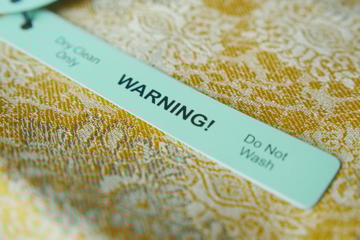 Warning label for delicate fabric care on a textured background photo